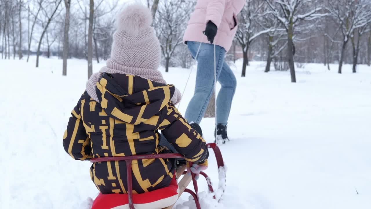 一个女人和她的女儿一起滑雪橇。视频素材