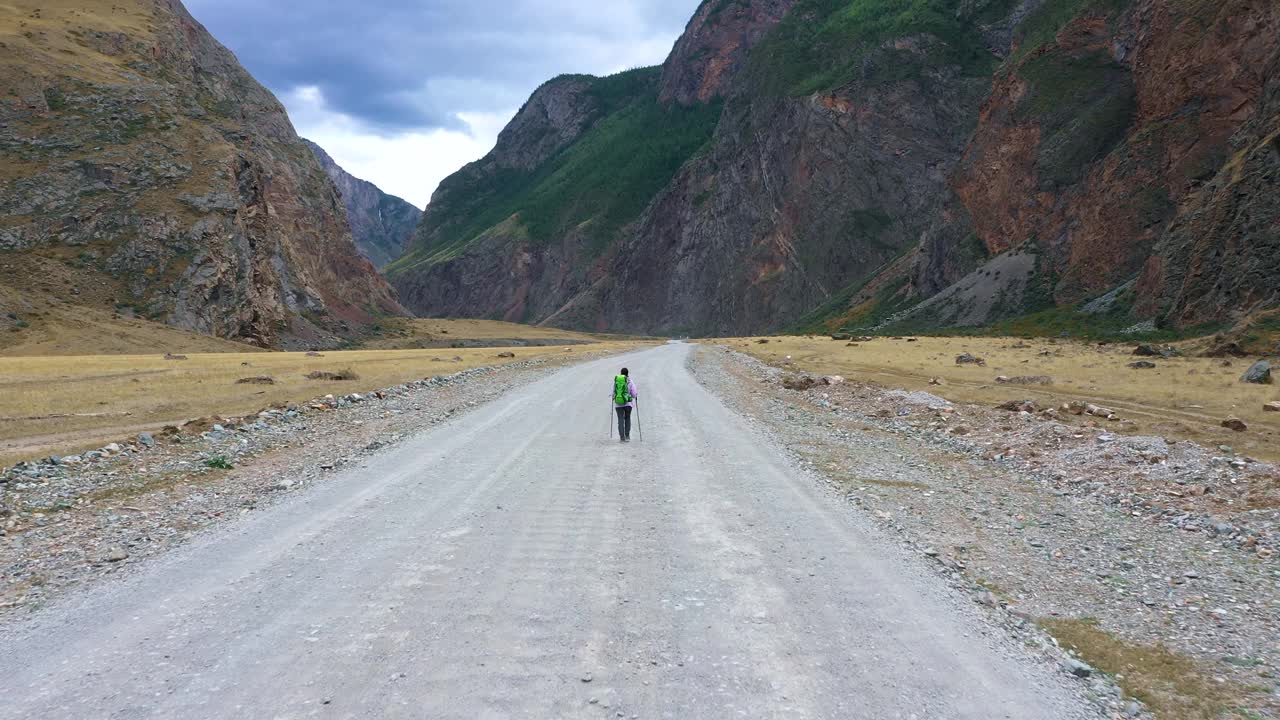 背包旅行者在山上的碎石路上徒步旅行视频素材