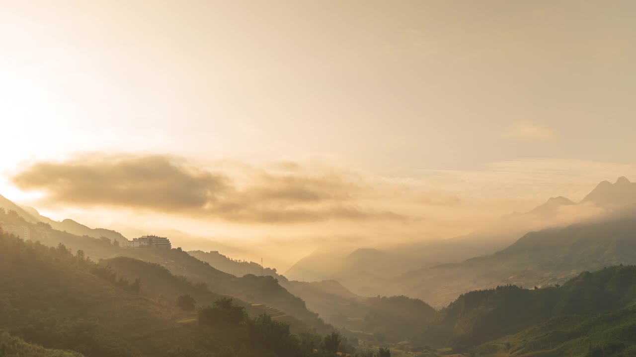 时光流逝，日落山峦，风景秀丽薄雾，黄昏金色时光，天空戏剧性。时光流逝美丽的风景运动高山山脊薄雾平移全景风景黎明戏剧性的天空。视频素材