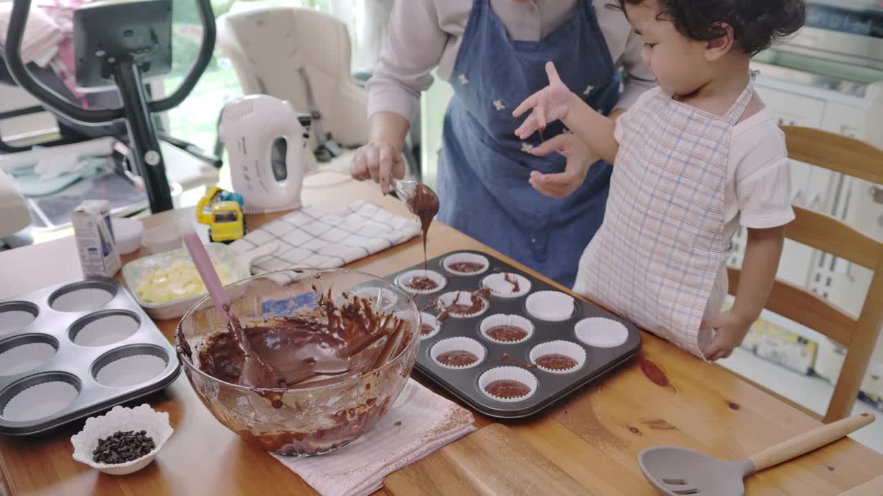 母亲和儿子一起做纸杯蛋糕。视频素材