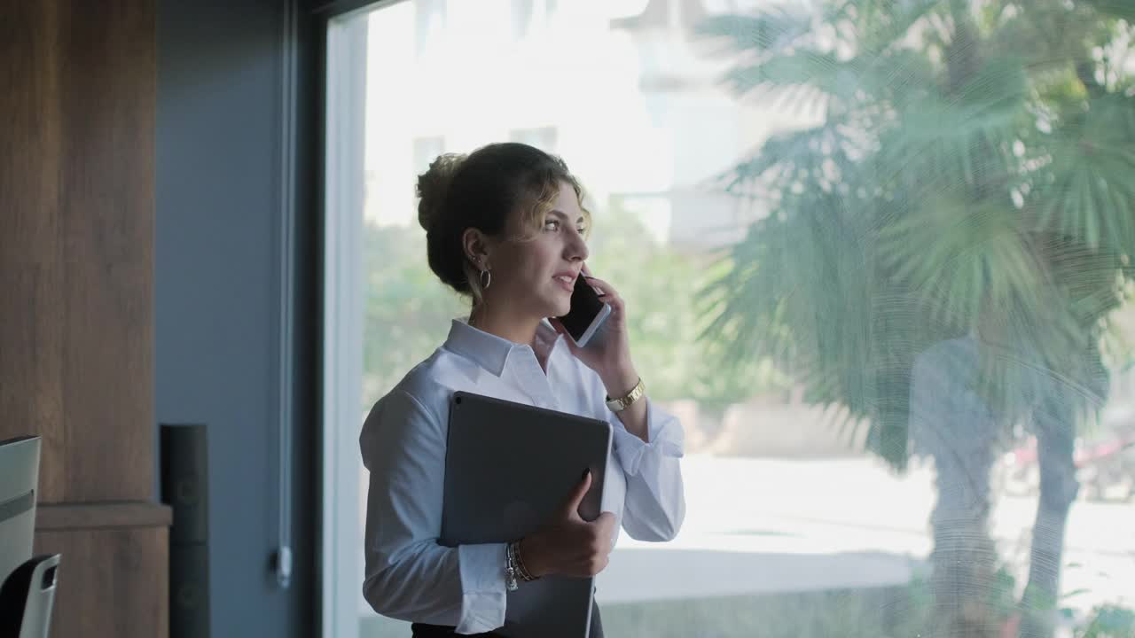 年轻女商人在办公室打电话的照片视频素材