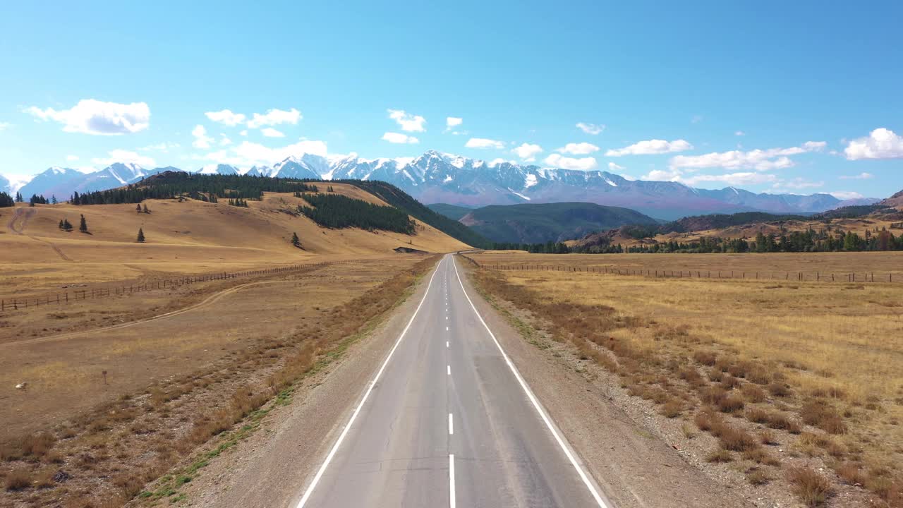 柏油路通过沙漠背景雪山鸟瞰图视频素材