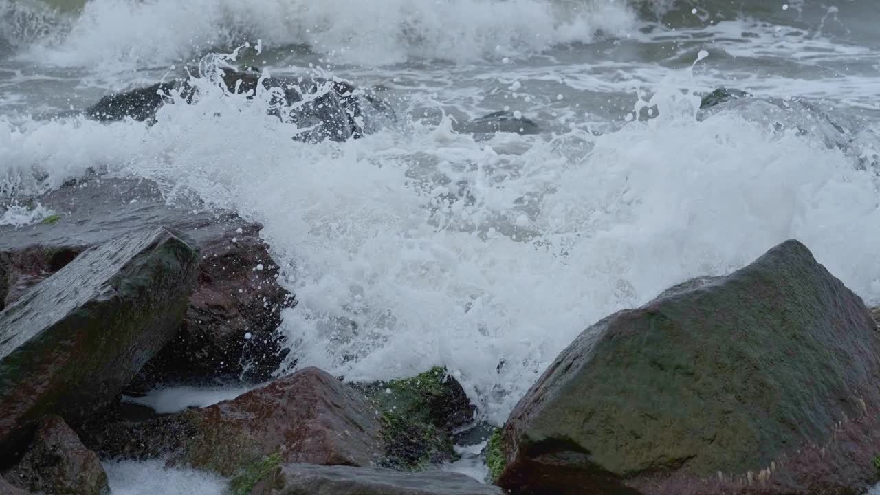 强烈的海浪冲击着海岸的巨石视频素材