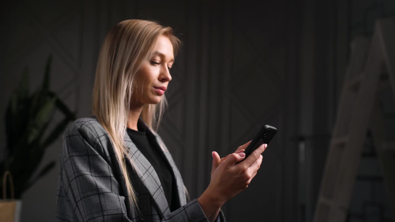 时尚的商业女士的肖像与智能手机在手。女人冲浪社交活动。视频素材