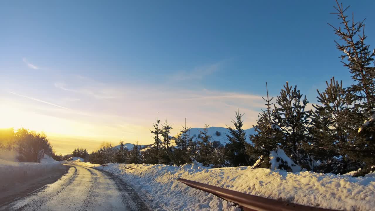 日落时分，在冬季森林的雪道上行驶视频素材