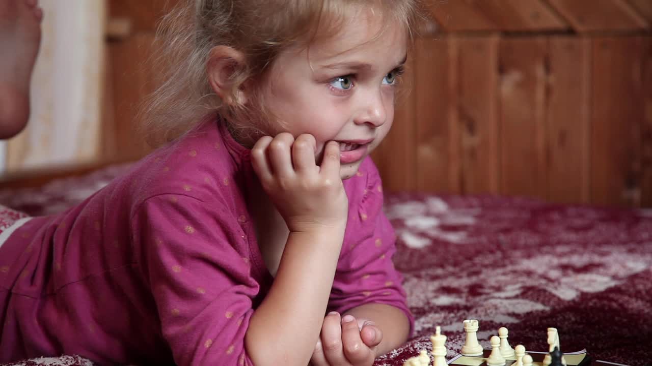 小女孩在床上下棋时消极地摇着头视频素材