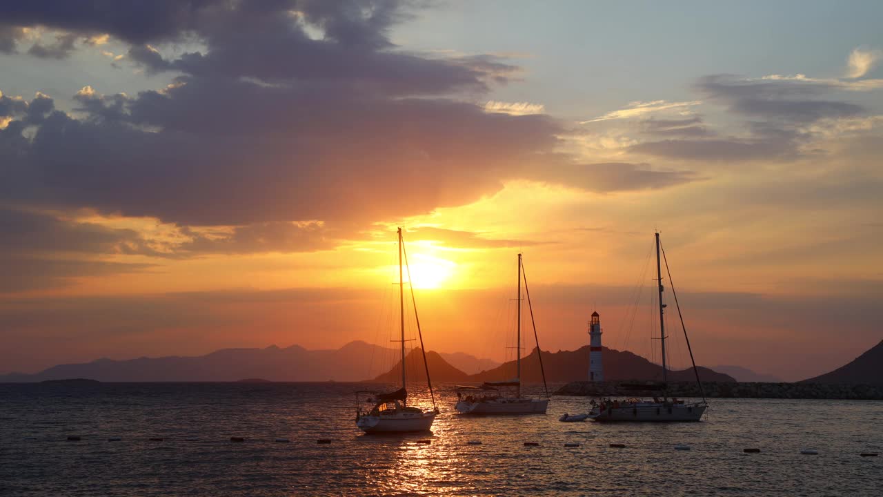 在夕阳海景。海岸上的灯塔。海边小镇Turgutreis和壮观的日落视频素材