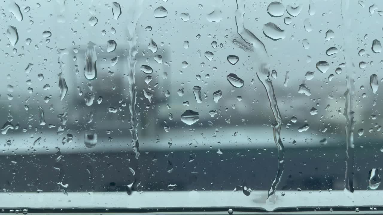 落下的雨打在玻璃上视频下载