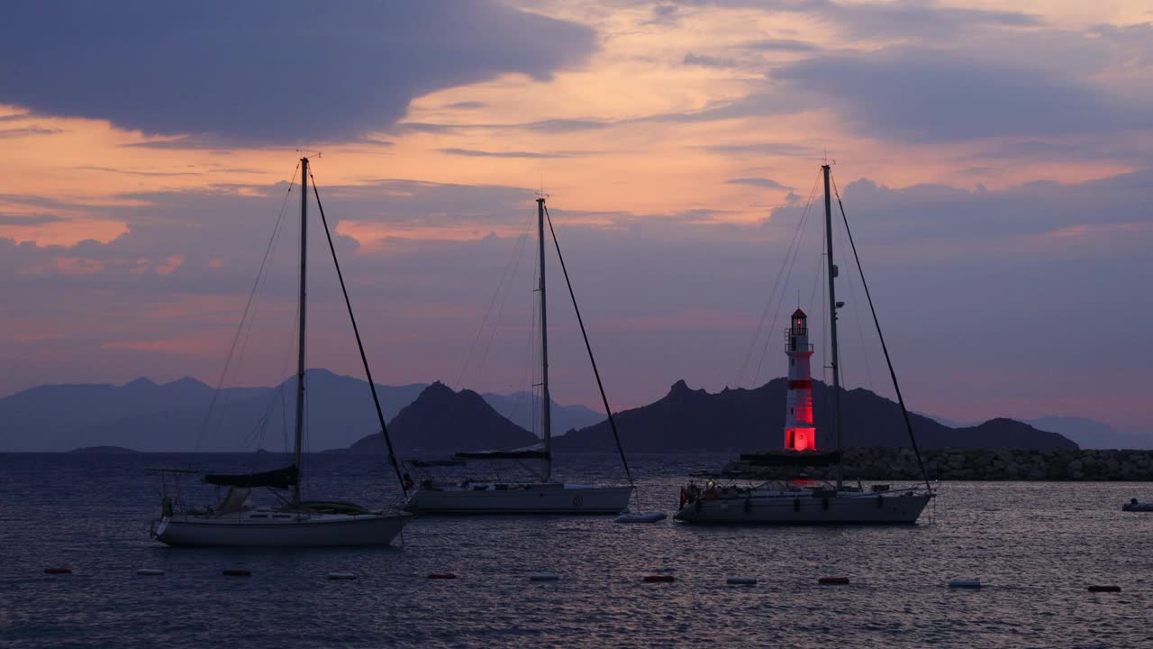 在夕阳海景。海岸上的灯塔。海边小镇Turgutreis和壮观的日落视频素材