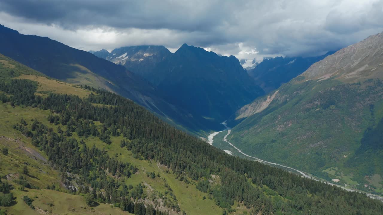 鸟瞰图的山河流经山谷在积雪覆盖的山峰。视频素材