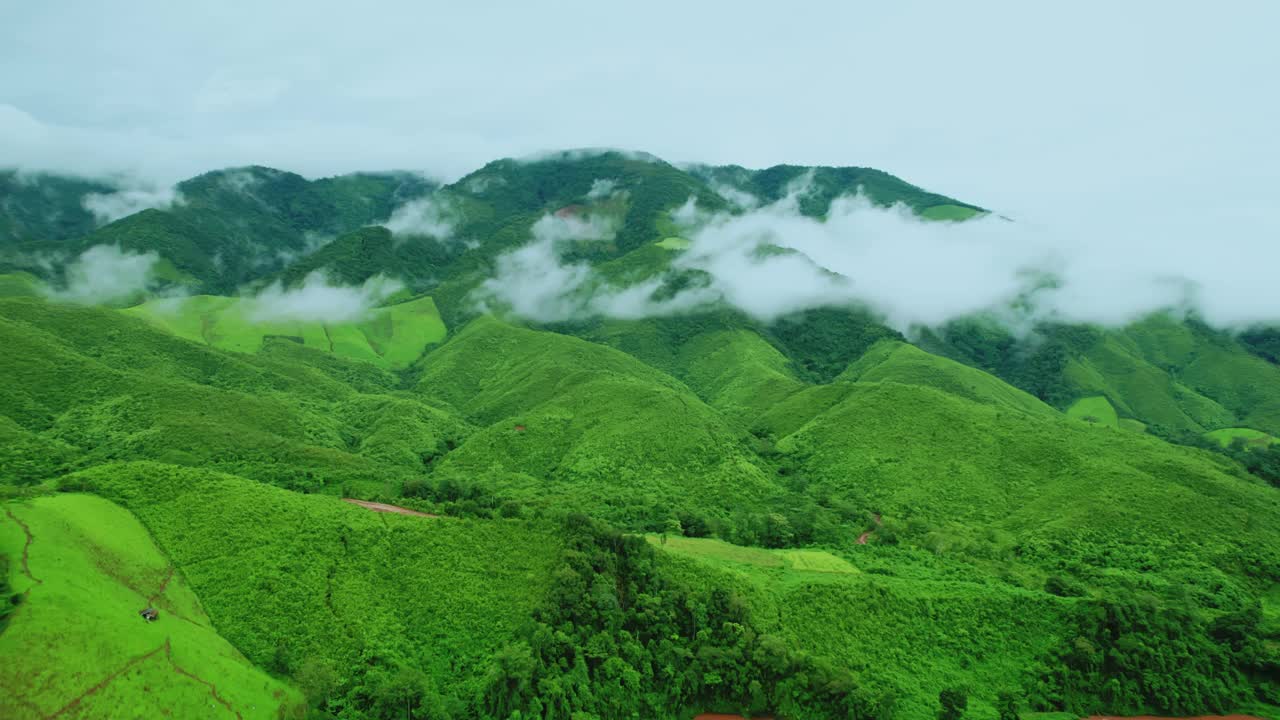 鸟瞰无人机拍摄的流动的雾波在山区热带雨林在晚上，鸟瞰图像在云上惊人的自然背景与云和山峰。视频素材