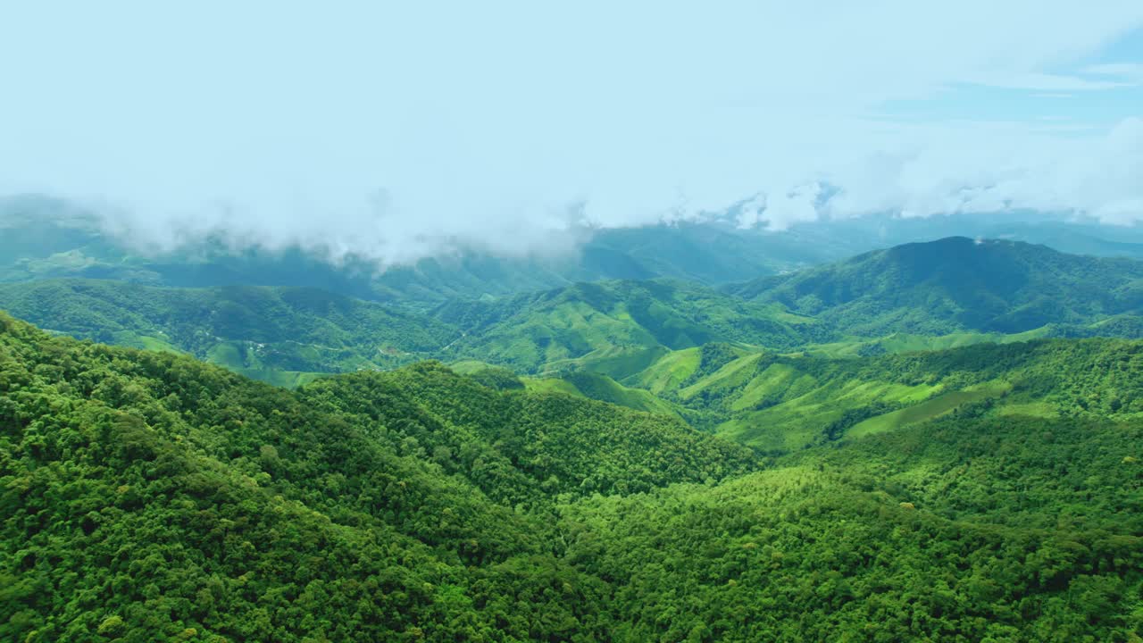 鸟瞰无人机拍摄的流动的雾波在山区热带雨林在晚上，鸟瞰图像在云上惊人的自然背景与云和山峰。视频素材