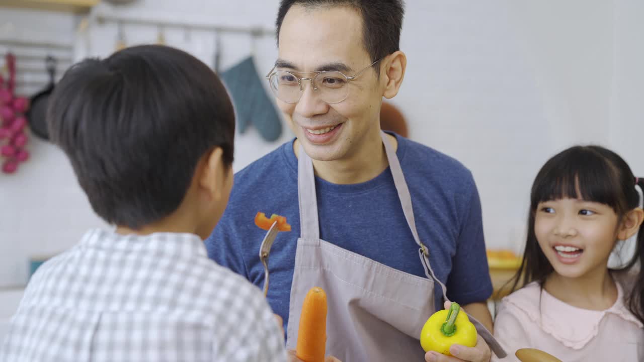 幸福的家庭，爸爸和孩子们一起做饭。视频素材