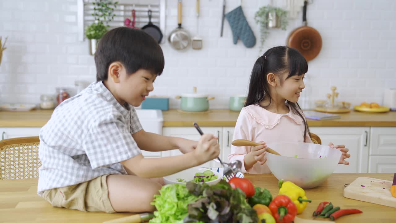 亚洲兄弟姐妹一起在厨房做饭。视频素材