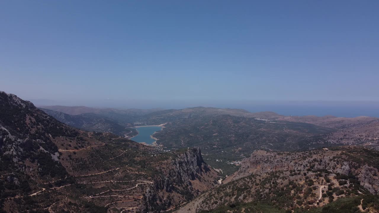 空中自然希腊风景与海，山，橄榄树和房屋在克里特岛。夏季度假旅游目的地。视频素材