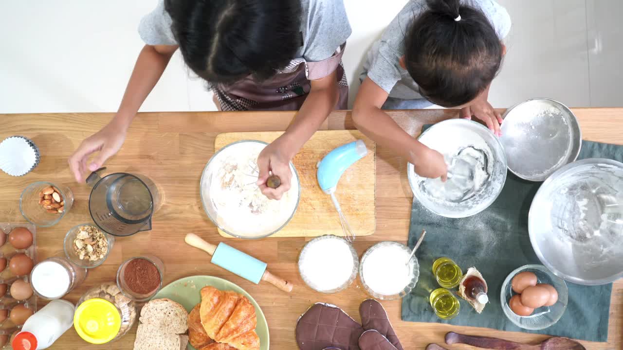 两个小女孩在家里的厨房里做饭视频下载