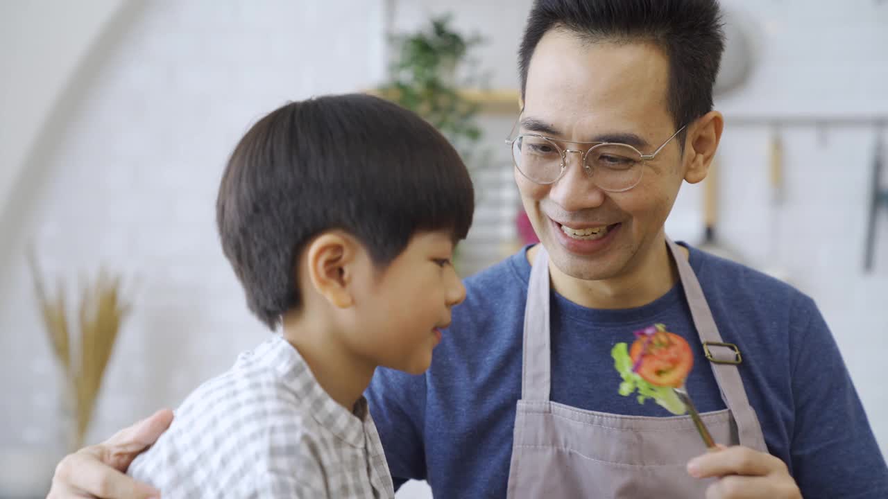 幸福的家庭，爸爸和孩子们一起做饭。视频素材