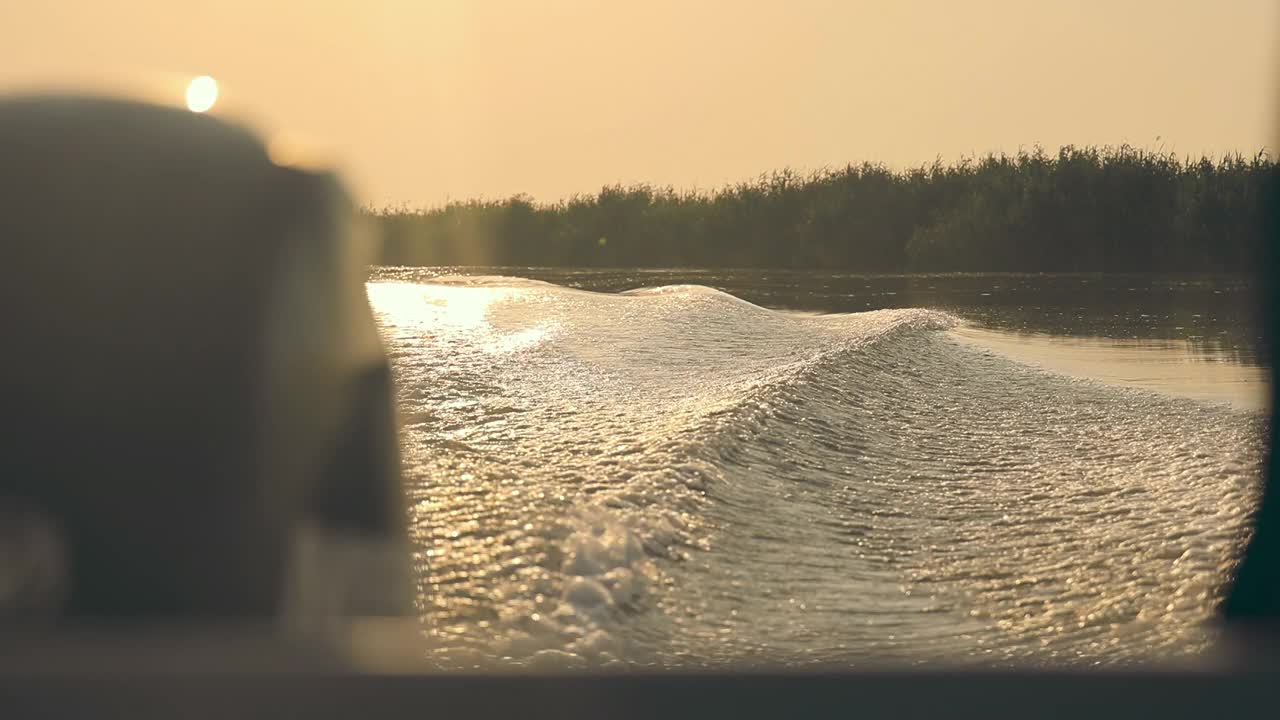 日落时分，摩托艇在波浪上的美丽景色。在日落时乘摩托艇旅行视频素材