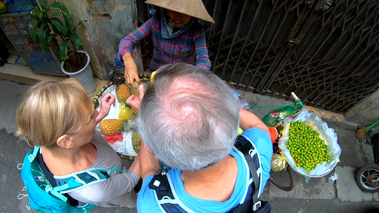 头顶上的高加索游客选择河内水果市场小贩视频素材