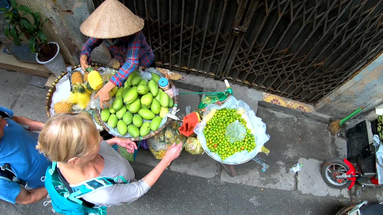 头顶上的高加索游客选择河内水果市场小贩视频素材