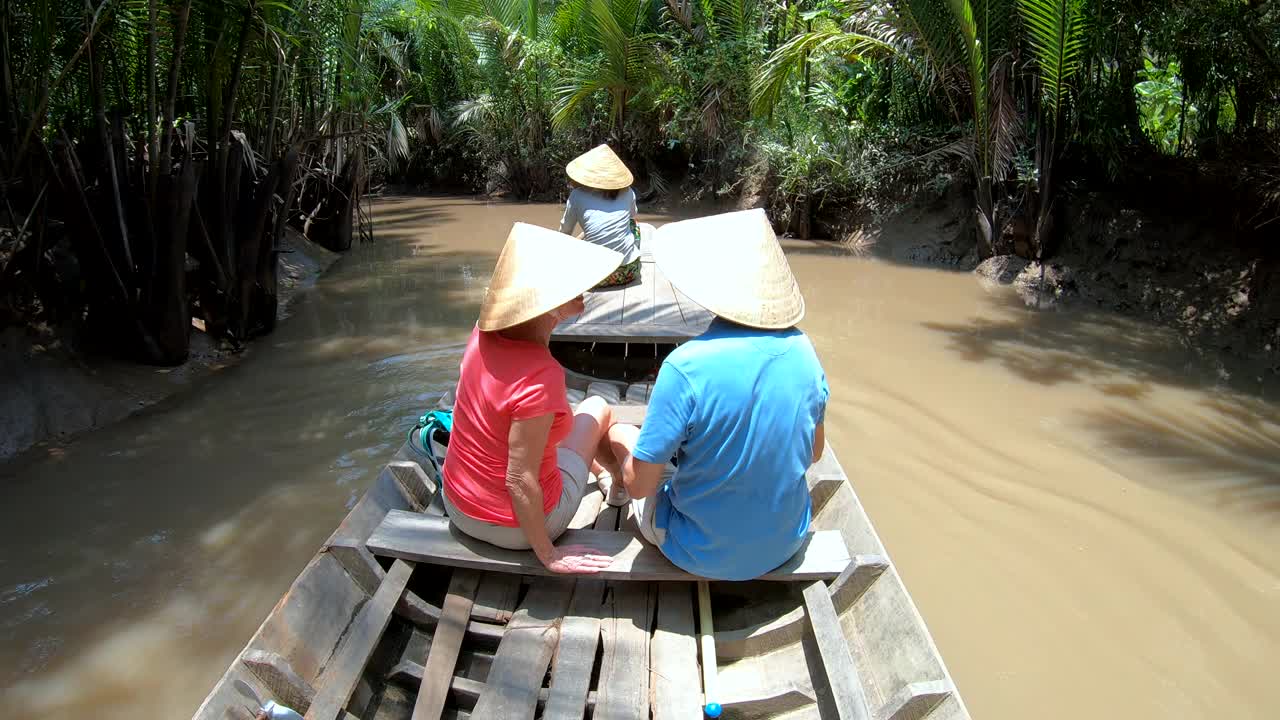 成熟的旅游夫妇戴着锥形帽子湄公河越南视频素材