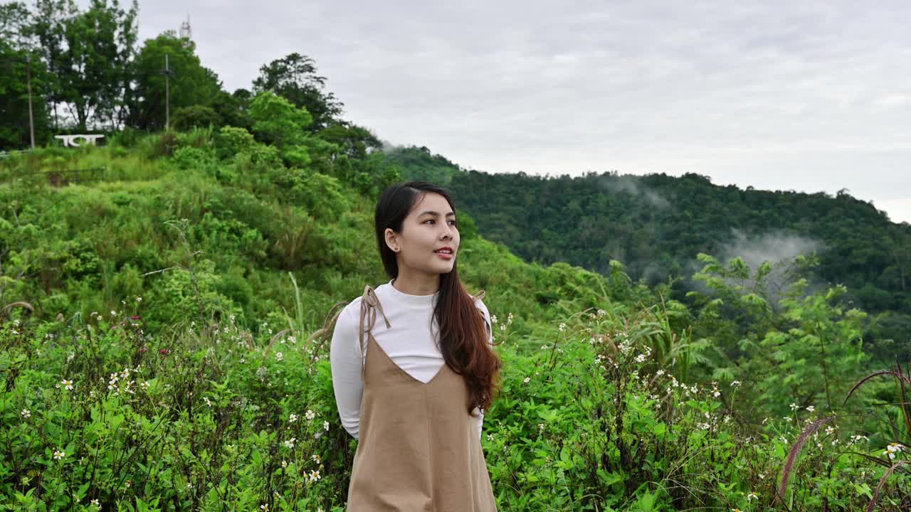 年轻的亚洲女人散步和看自然风景在早上视频素材