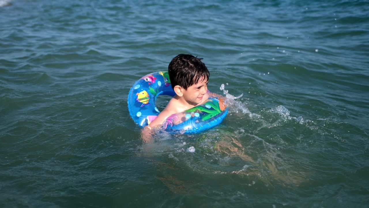 小男孩在海浪中玩耍和戏水视频素材