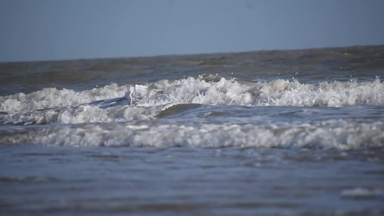 海浪冲击着印度古吉拉特邦库奇的曼dvi海滩。美丽的热带海滩与蓝色的天空与海浪冲击空海滩在夏天视频素材