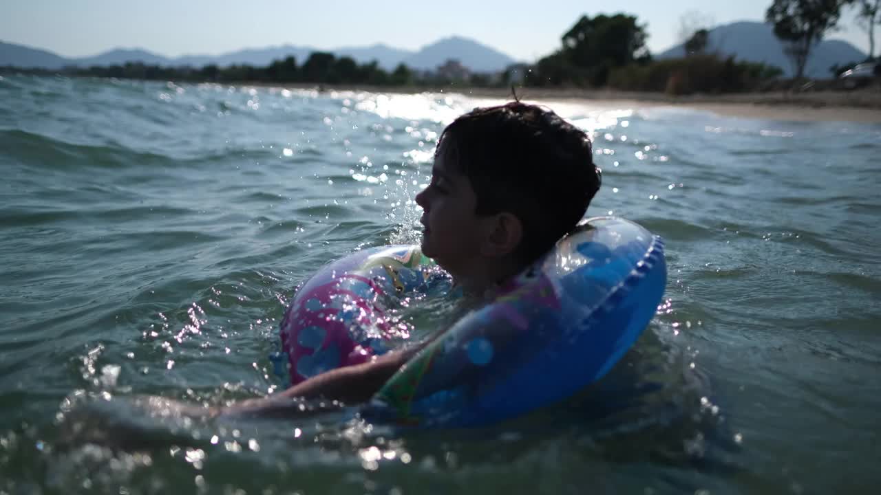 小男孩在海浪中玩耍和戏水视频素材