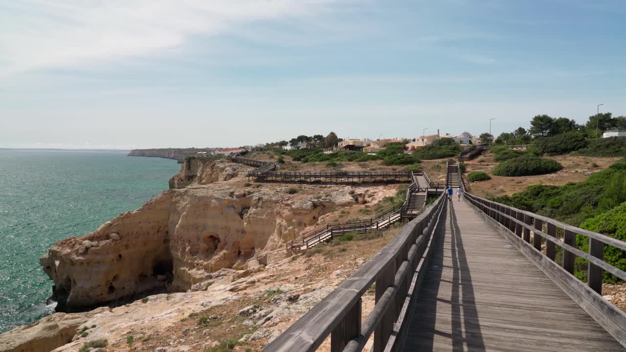 沿着木路散步，你会看到夏天葡萄牙卡沃埃罗海岸的美妙景色。俯瞰蓝色的大海。用稳定器在运动中射击。视频素材