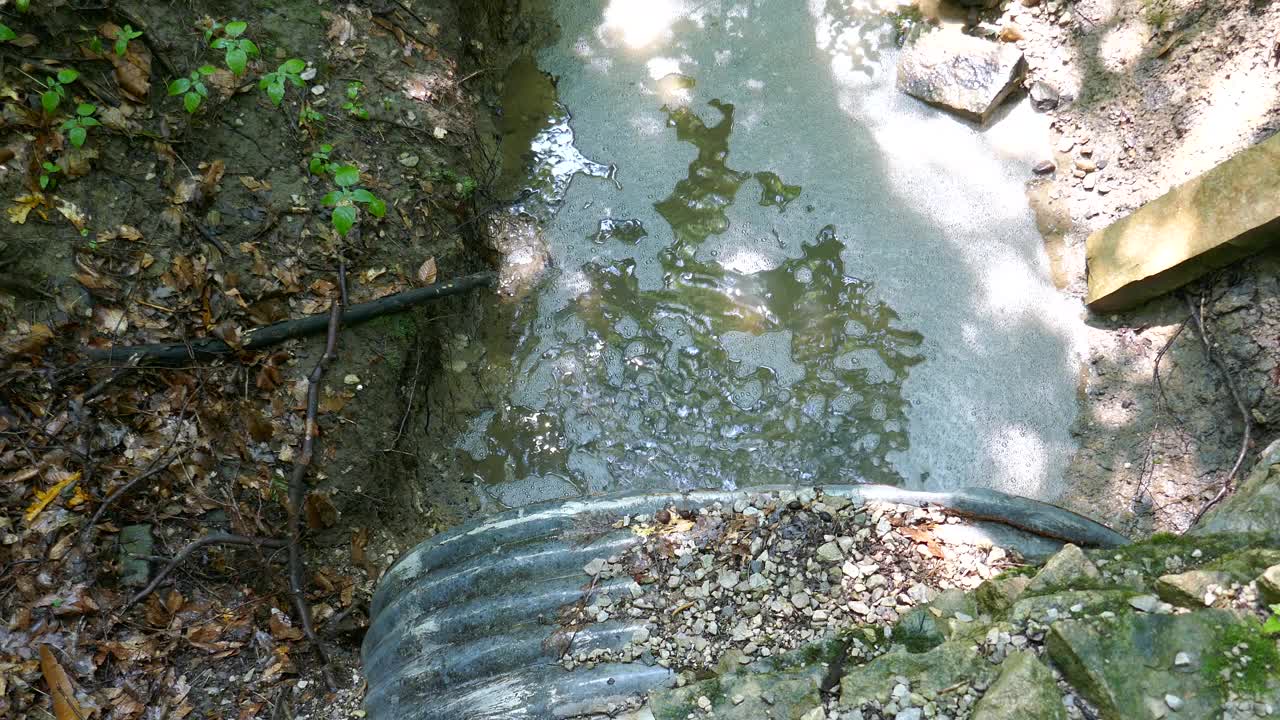 金属排水管，径流水流入小溪视频素材