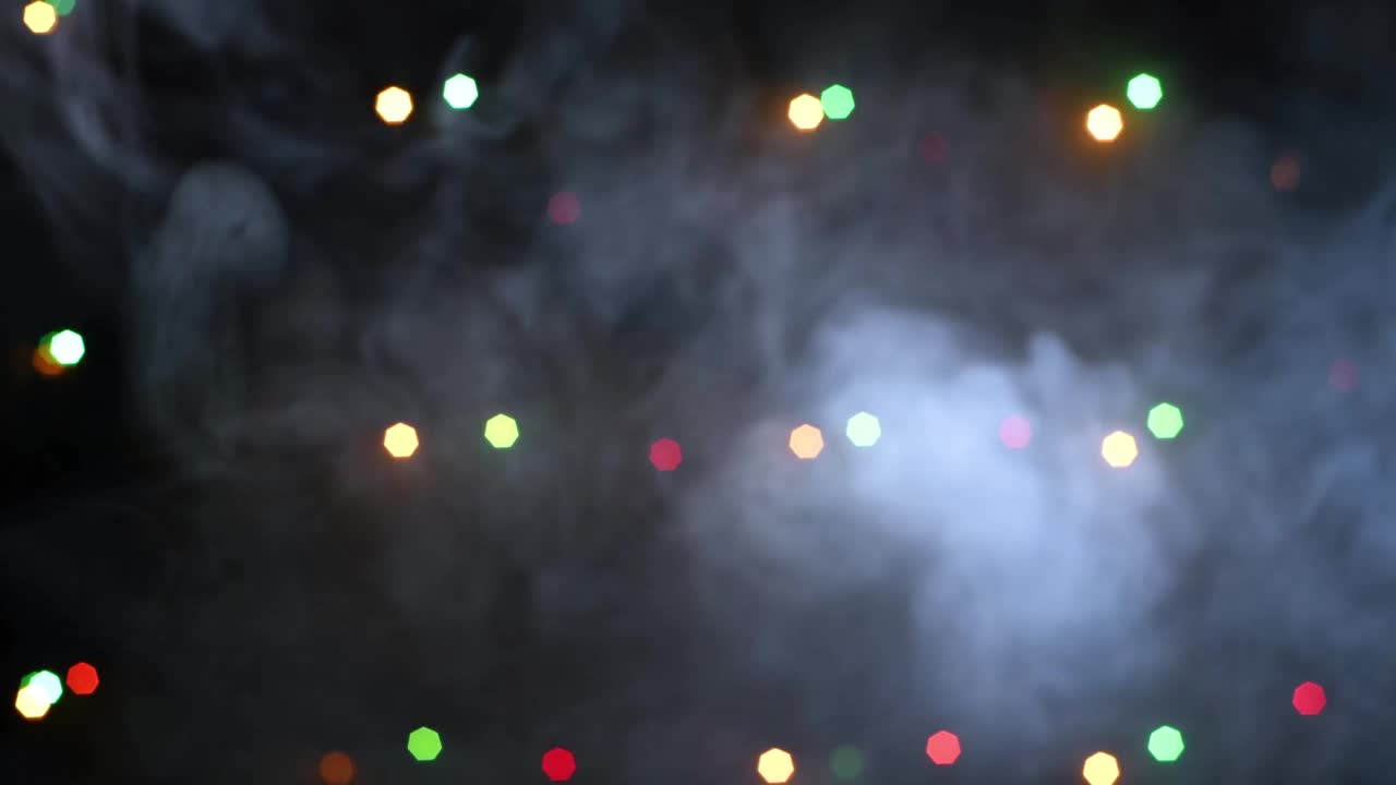 真实的烟雾与闪烁的彩色灯在黑色背景视频素材