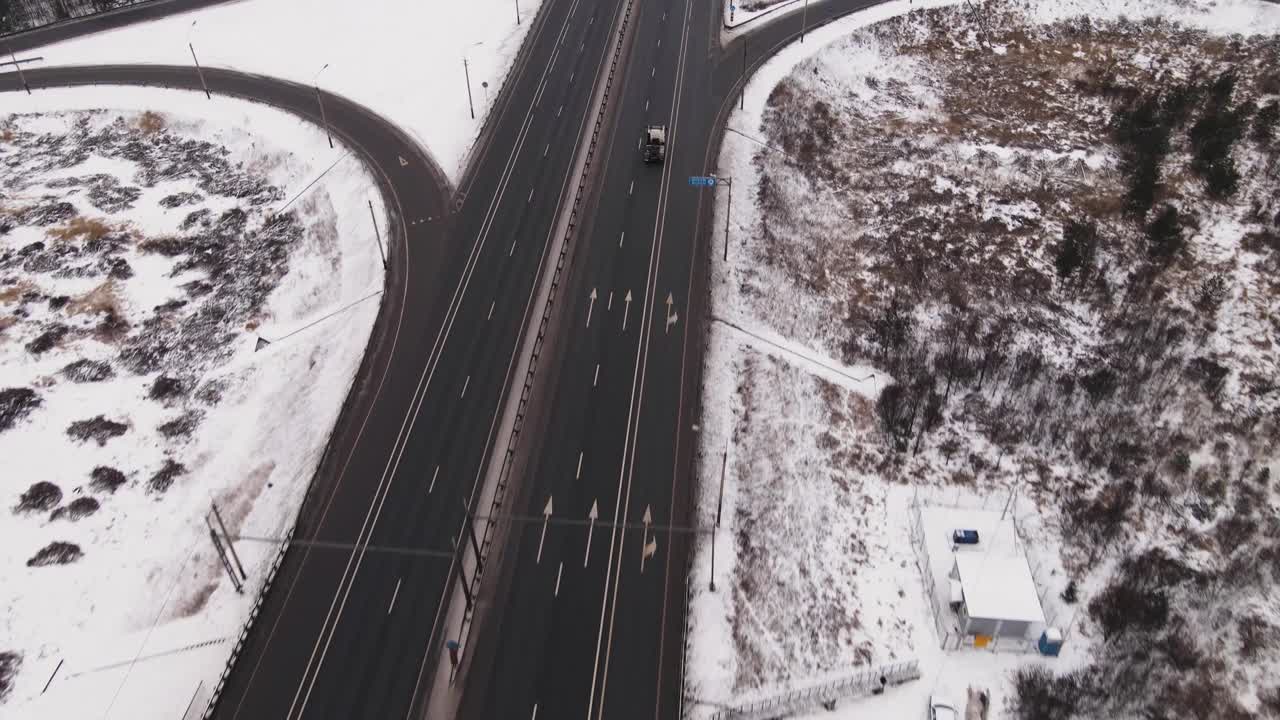 郊区高速公路的环形和快速移动的汽车在冬天，鸟瞰图。视频素材