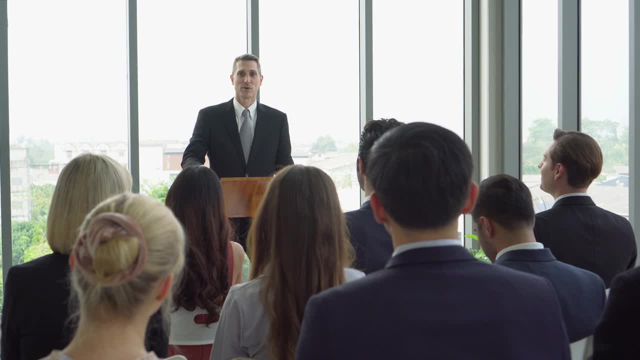 在研讨会上，资深企业家站在讲台上发表演讲。老执行官在办公室的窗口与同事开会视频素材