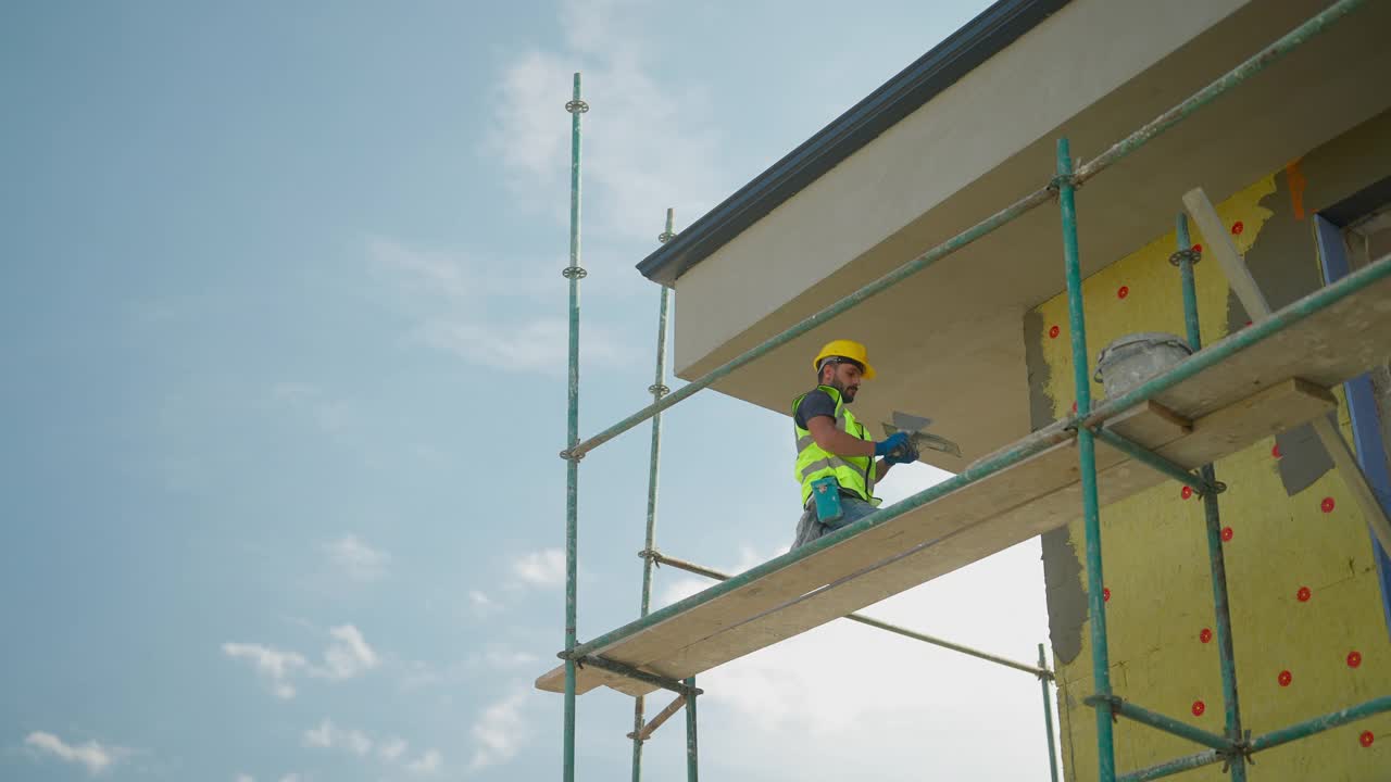 建筑工人在建筑外立面涂石膏视频素材