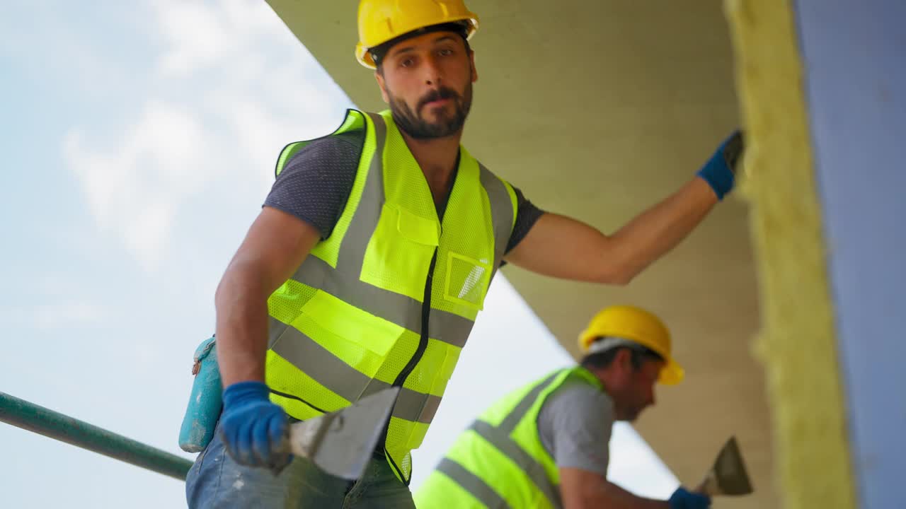 建筑工人在建筑外立面涂石膏视频素材