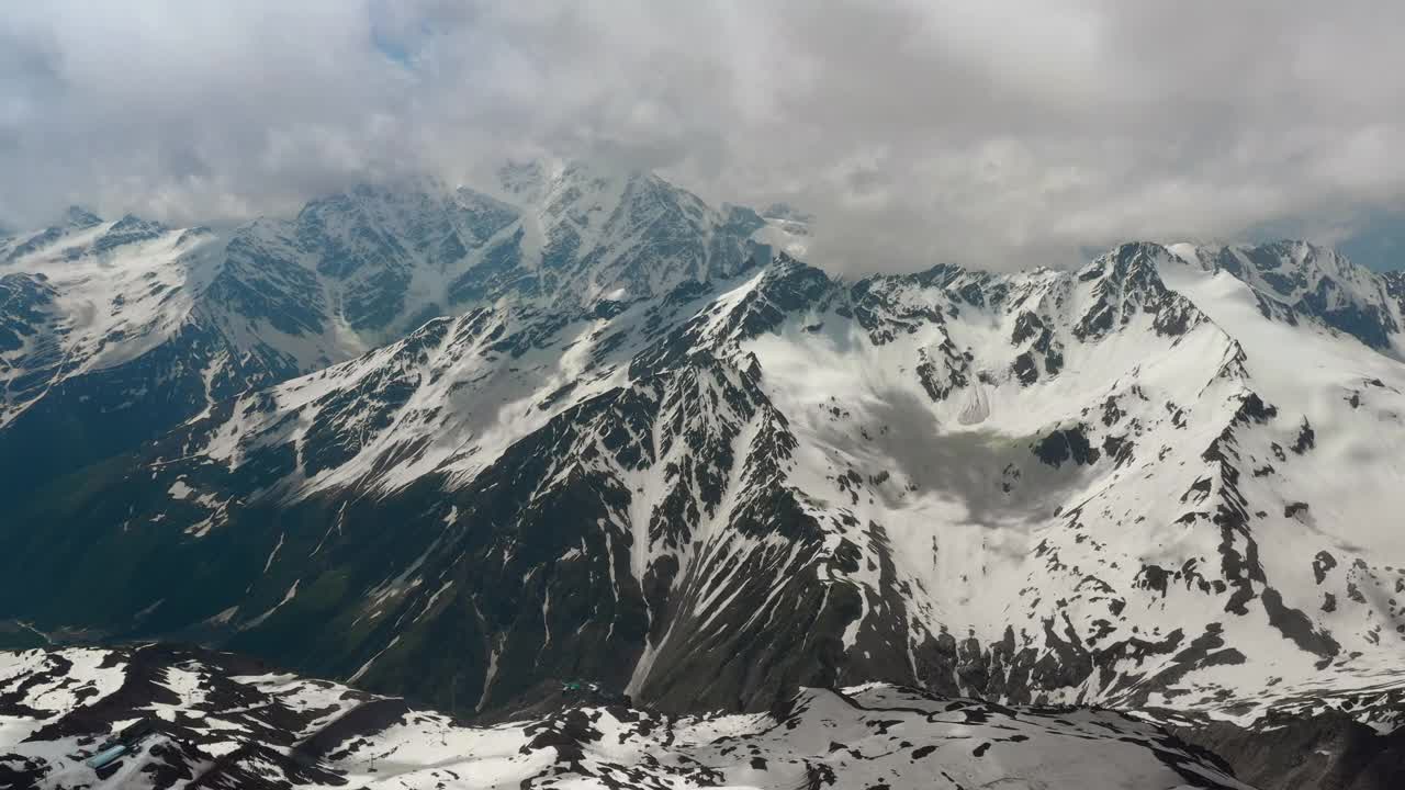 在美丽的雪峰和冰川上空的云朵中飞行。视频素材