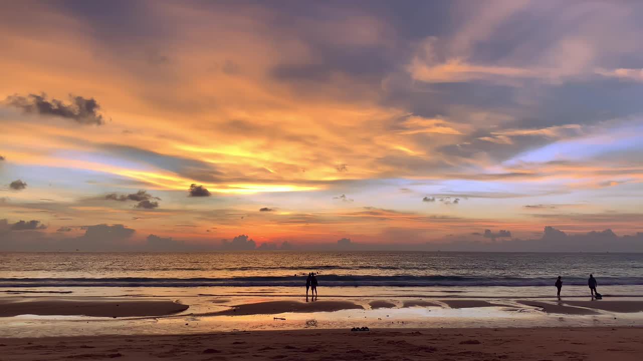 美丽的夕阳和人们站在海边的热带岛屿视频素材