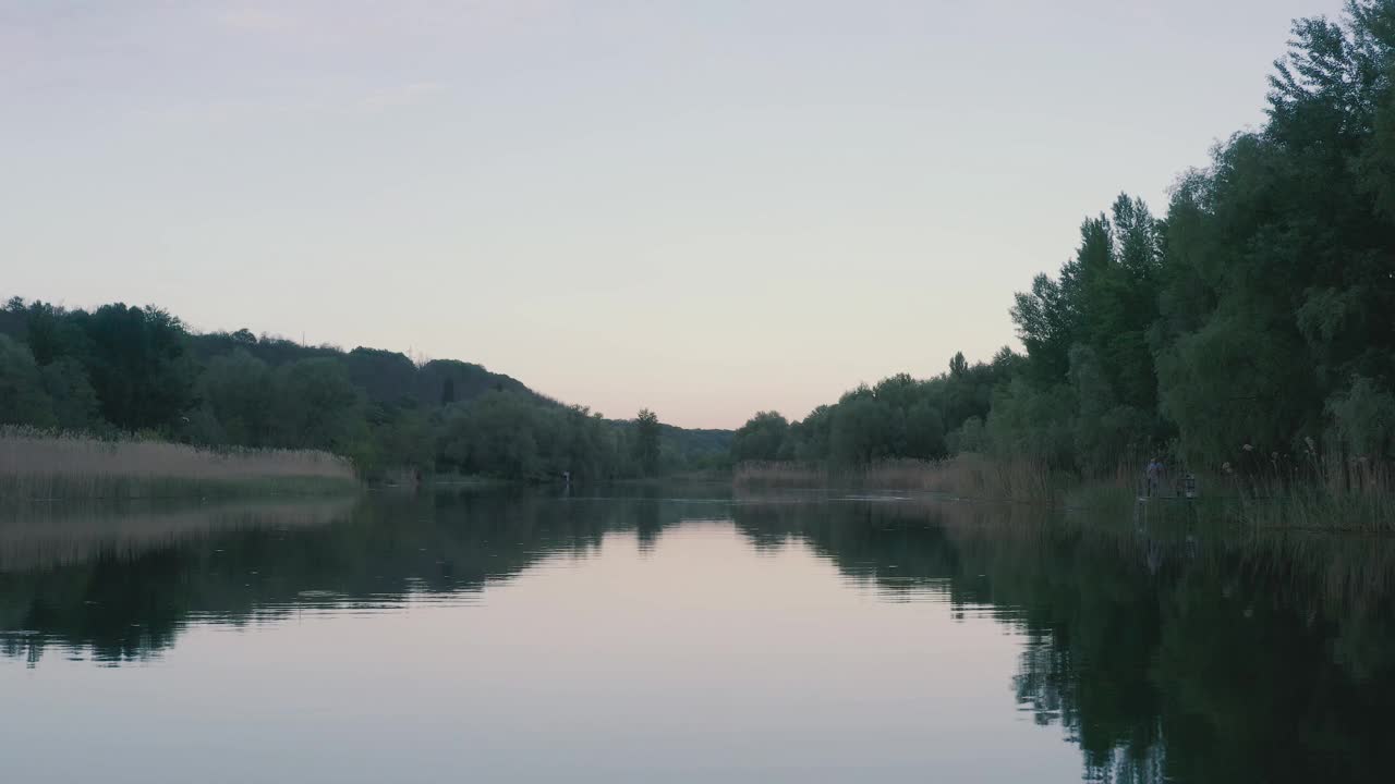 黄昏景观河无波。船浮在水面上，树长在岸边。美丽的云倒映在水中。视频素材