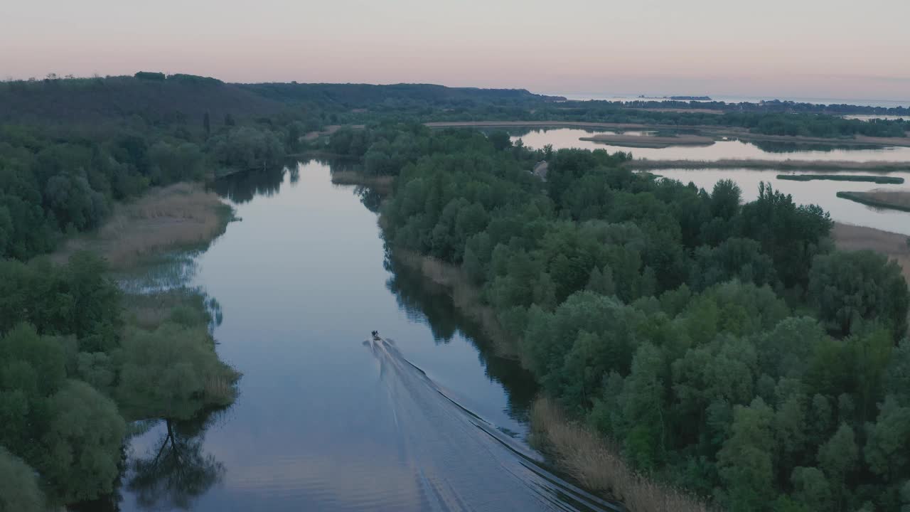 黄昏景观河无波。船浮在水面上，树长在岸边。美丽的云倒映在水中。视频素材