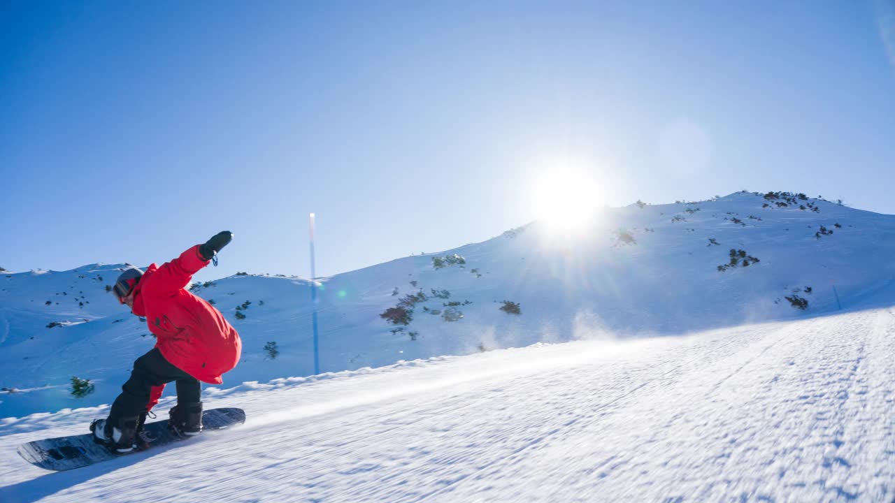 在一个完美的阳光灿烂的冬日，滑雪者在田园诗般的滑雪胜地滑雪道上滑行视频下载