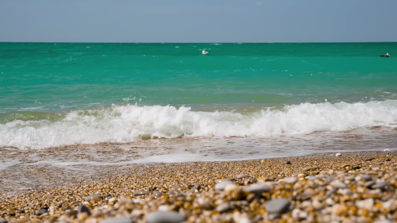 海浪在卵石滩上，美丽舒缓的背景。4 k的视频。视频素材