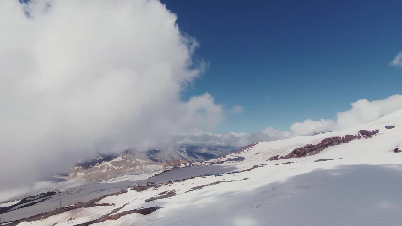 艾尔布鲁士山被雪覆盖的山峰透过厚厚的云层俯瞰视频素材