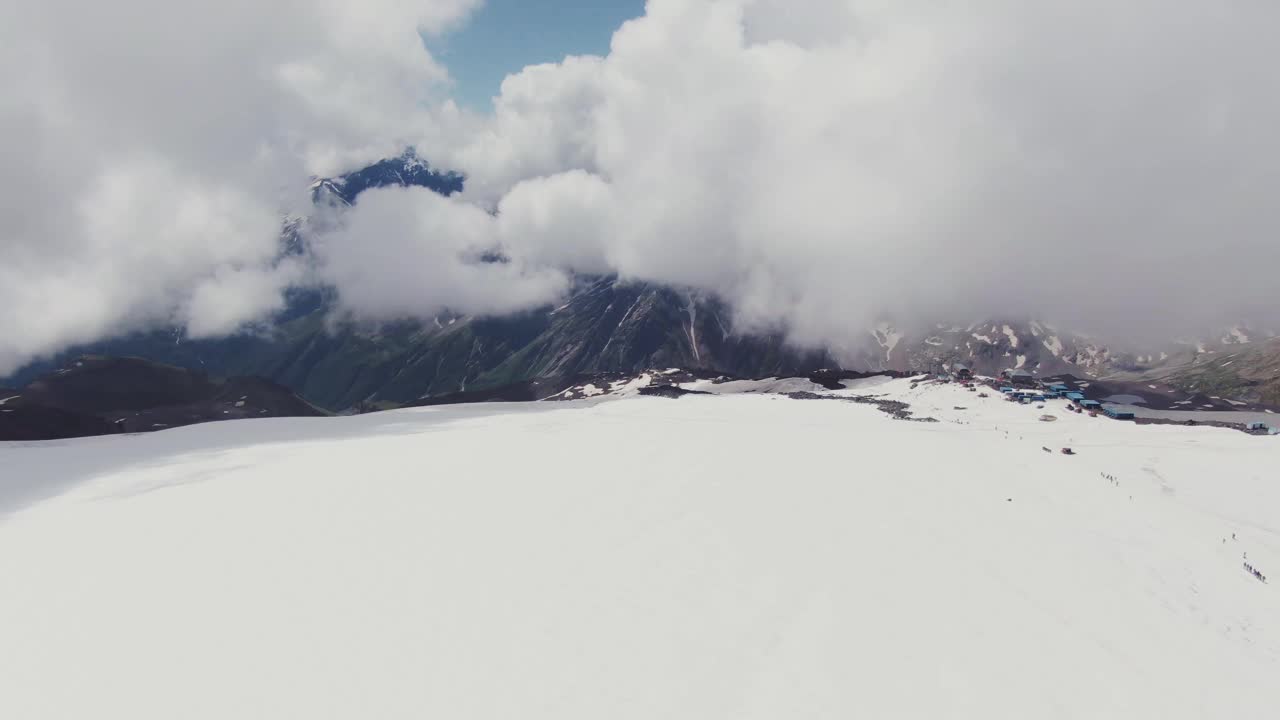 艾尔布鲁士山被雪覆盖的山峰透过厚厚的云层俯瞰视频素材