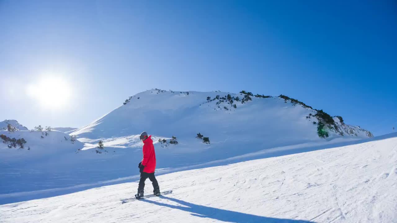 滑雪者在滑雪坡道上雕刻，喷雪，美丽的风景在后面视频素材