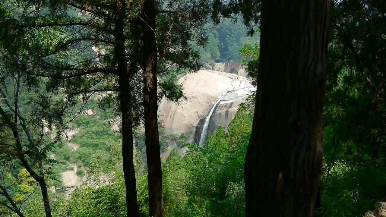 山间瀑布从多层石头，森林和灌木流进水池。视频素材