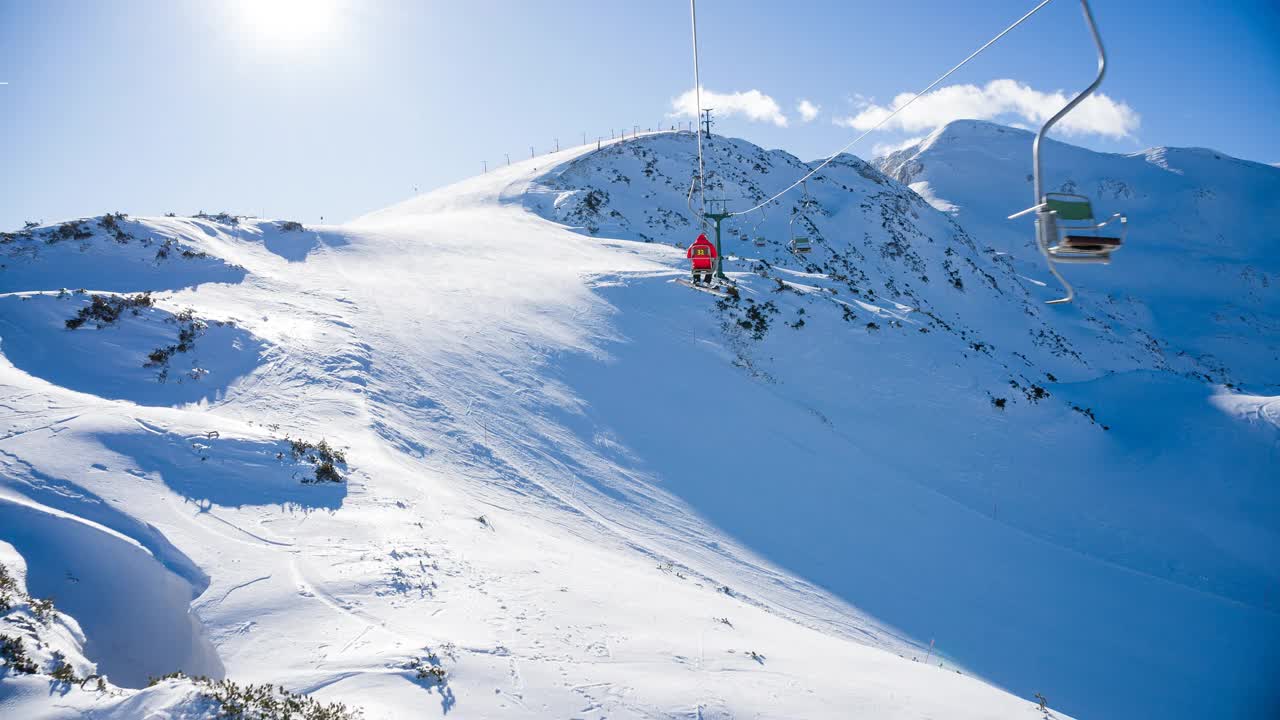 在滑雪胜地乘坐单人缆车到达雪山山顶视频下载