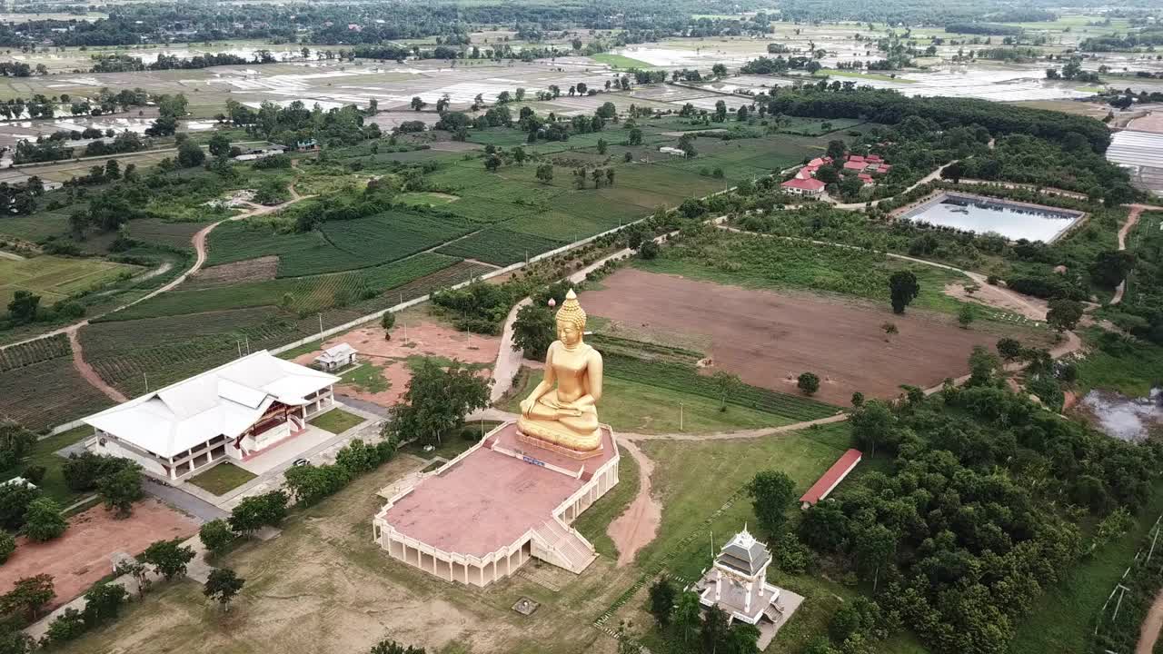 从无人机上鸟瞰为庆祝清莱古城建城750周年而建造的普塔蒙松(佛教公园)的大金佛雕像。视频素材