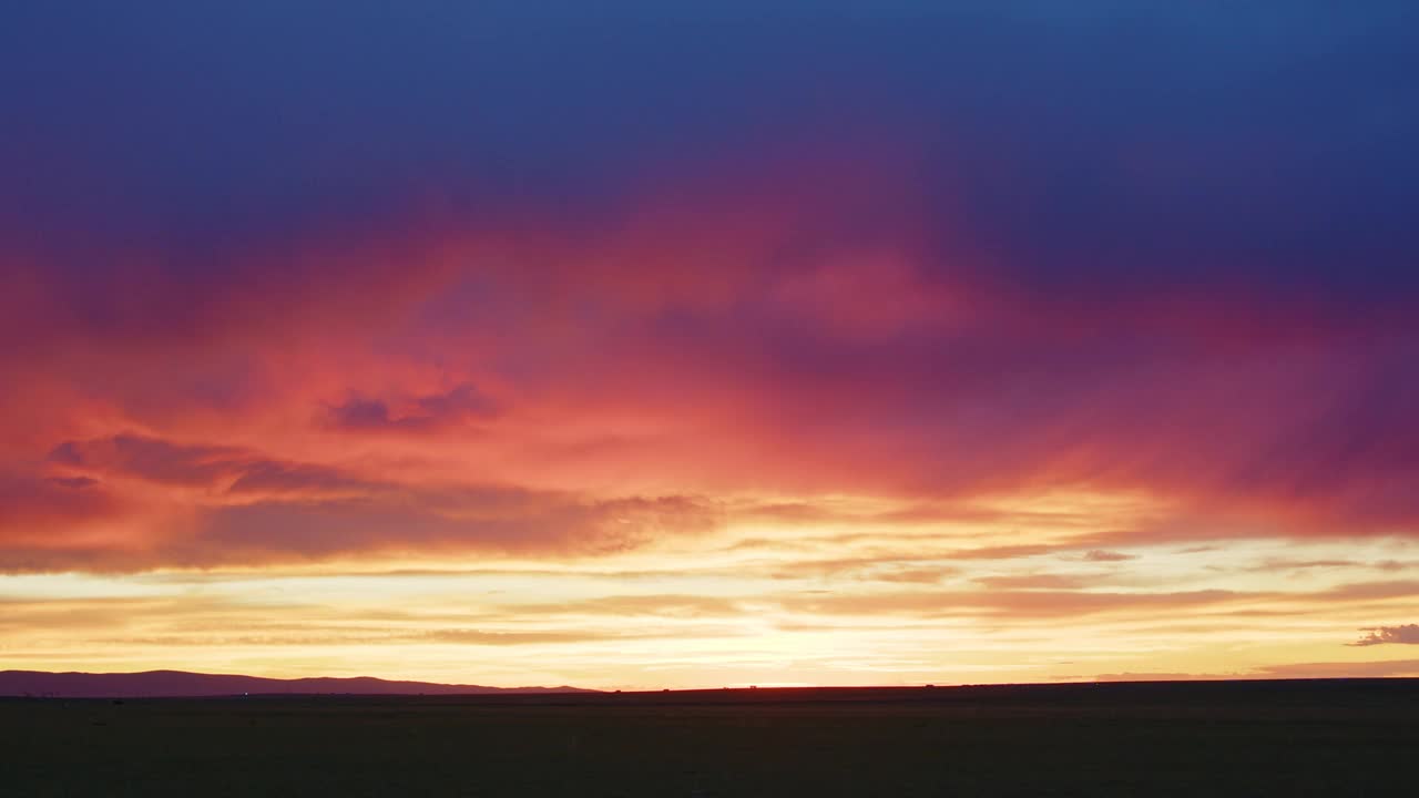 飞机在怀俄明州五彩缤纷的夕阳中飞过天空视频素材