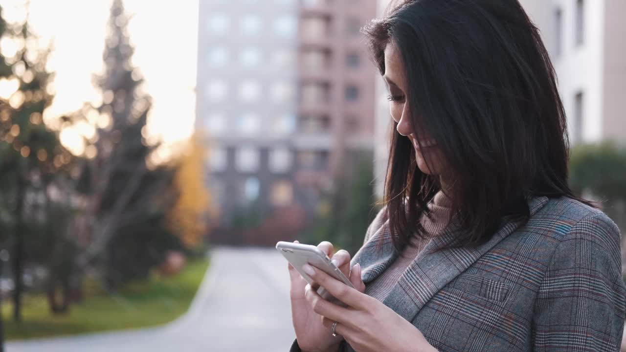 一位自信的商务女性在户外使用智能手机视频素材